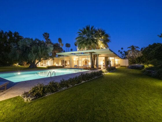The Koerner House at twilight, its low shed roof and lit glass walls reflected in the pool, Deepwell Estates, Palm Springs