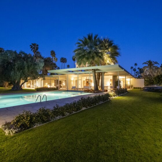 The Koerner House at twilight, its low shed roof and lit glass walls reflected in the pool, Deepwell Estates, Palm Springs
